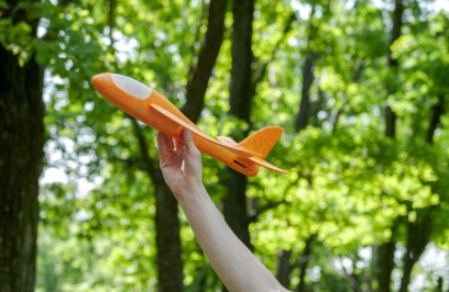 Orange,toy,airplane,in,hand,on,the,background,of,a