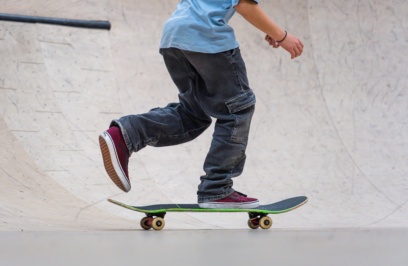 Teenager,balancing,on,skateboard,while,skateboarding,in,concrete,skatepark